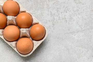 Holder with fresh chicken eggs on grey background, closeup
