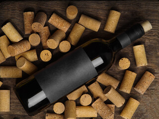 A bottle of red wine lies on wine corks. Lots of objects. Close-up. Winery, wine cellar,...
