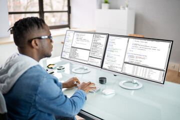 Obraz na płótnie Canvas African American Coder Using Computer At Desk