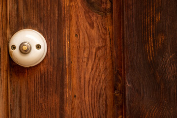 Old fashioned traditional style rustic doorbell button on a wooden door