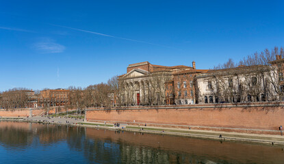 Obraz premium View from the water to the embankment of the river Garonne. City of Toulouse, France.