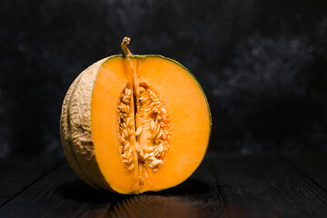 sweet melon on a dark background small delicious beautiful melon, both whole and in pieces and...