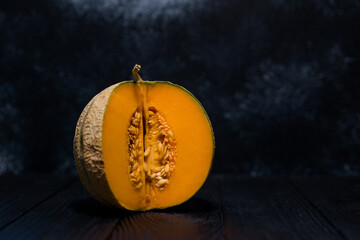 sweet melon on a dark background small delicious beautiful melon, both whole and in pieces and...