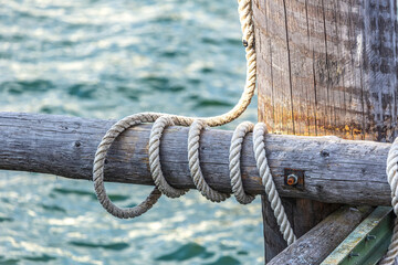 A hawser rope around a wooden post at a landing stage