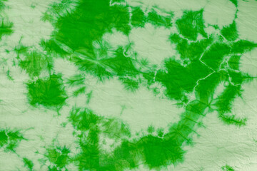 Green batik fabric is made from cotton and dyed with natural colors for background.