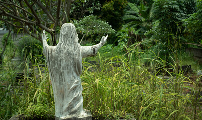 Statue of Jesus Christ from the back in the grave yard