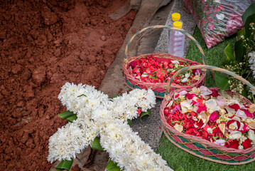 Cross bouquet on top a grave after burial ceremony