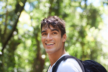 Surrounded by natures beauty. Shot of a handsome young man hiking in the forest.
