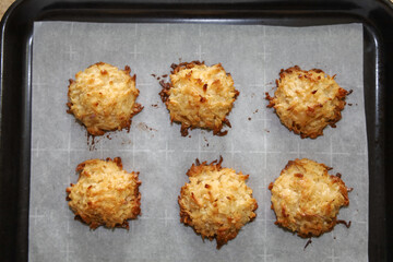 Golden brown Mexican coconut macaroons or cocadas on a baking pan.