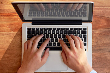 Hes a hands-on business man. Cropped shot of a businessmans hands on a laptop keyboard.