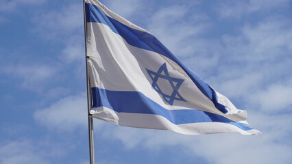 Israeli flag weaving in the wind against bright skies