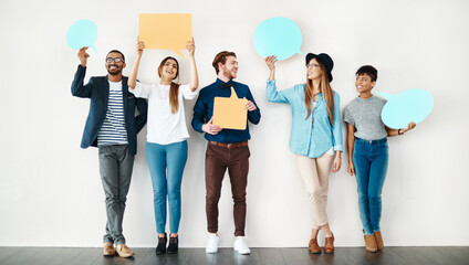 We want to share our thoughts. Shot of a diverse group of creative employees holding up speech bubbles inside.