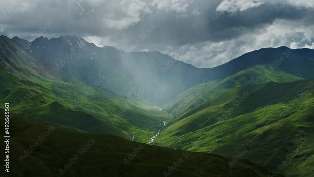 Wall mural beautiful mountain landscape with rain clouds and sun rays in canyon, 4k