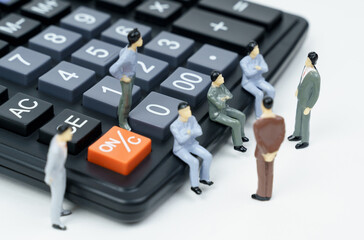 On the calculator and next to it there are miniature figures of businessmen - they are conferring.
