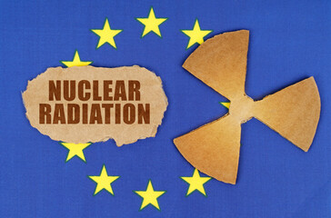 On the flag of the European Union, the symbol of radioactivity and torn cardboard with the inscription Nuclear Radiation