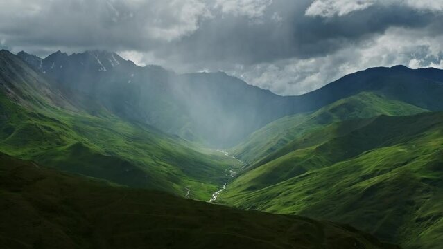 Beautiful mountain landscape with rain clouds and sun rays in canyon, 4k