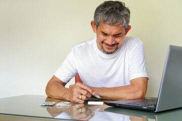 asian senior man doing Covid-19 ATK self test which searching procedure by computer laptop © Verin