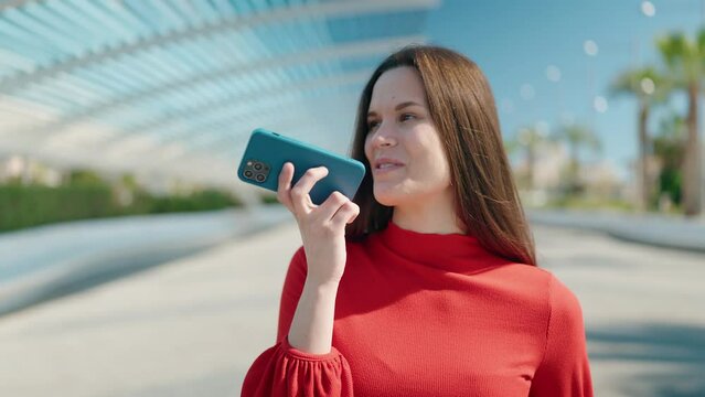 Young woman talking on the smartphone walking at park