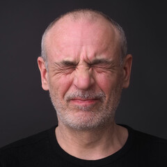 man with closed eyes emotion of pain on his face