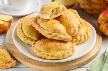 Baked  pasties stuffed with apples. Pirozhki - russian baked puff pastry with apple fillings. Homemade fruit pies. Selective focus