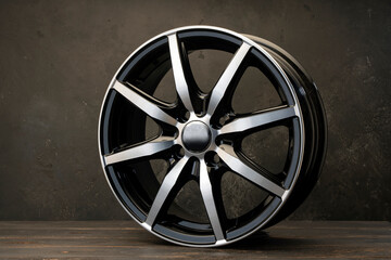 new black alloy wheels on a dark textured black background. wheel for car spare parts auto repair tire shop,