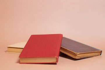 A stack of old worn books on a colored background