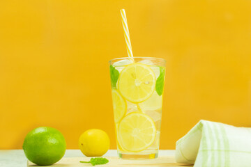 Cool lemonade from fresh lemons and mint on a yellow background