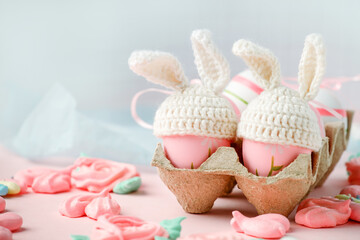 Fototapeta na wymiar Happy Easter holiday concept with cute handmade eggs, knitted bunny hats and sweet pink decor, copy space. Greeting card, banner for your site, flyer, banner, invitation, discount card