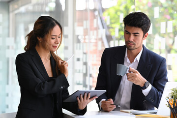 Two business people sharing ideas consider strategy, discussing online presentation at modern workplace.