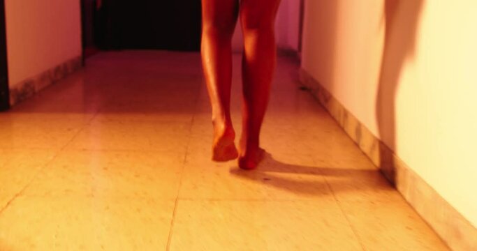 Scared and staggering black woman walking in the corridor in a gloomy atmosphere