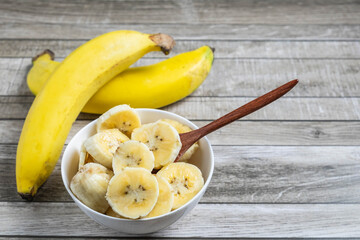 Fresh bananas and bananas cut into pieces in a bowl for health on the table.