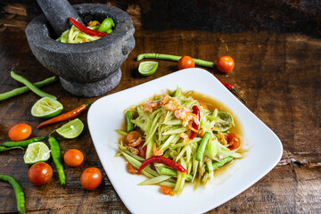 .Cooking Thai food, papaya salad and papaya salad in a dish with a serving on a wooden table.