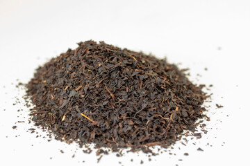 Dry black tea grains isolated on white background.