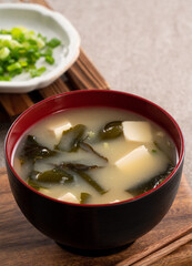 Delicious savory Japanese miso soup in a black bowl for eating.