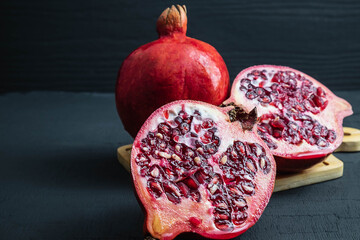 Pomegranate fruit sliced ​​on a black background