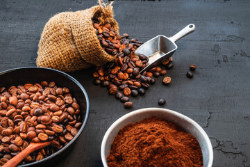 Coffee beans and coffee powder on a black wooden background
