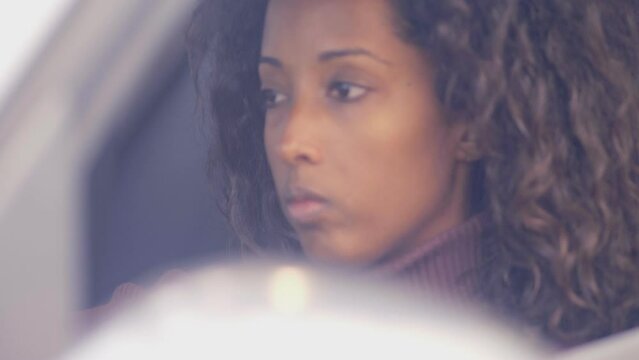 Upset african american woman sitting in new modern car. She is very sad