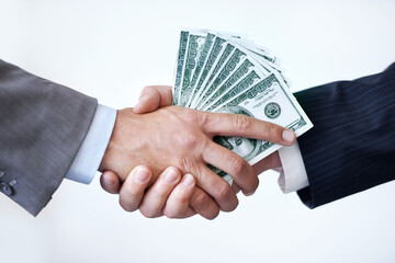 If you do this for me.... Studio shot of two men shaking hands after making a monetary deal.