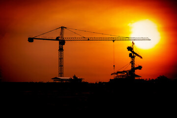 those tower cranes were used to create built and in the picture, there was a construction site with sunset.