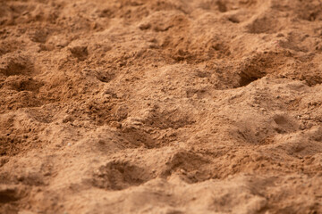 photo of the sand surface in orange-brown tones, close-up. Texture, background