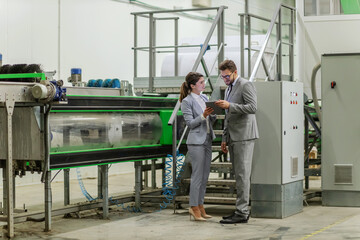 Fototapeta premium Machines and people in suits in factory.