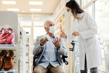 An old disabled man asking for pharmacist opinion about medicine.