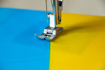 The flag of Ukraine on a home sewing machine, the production of national flags for Ukraine, stop...