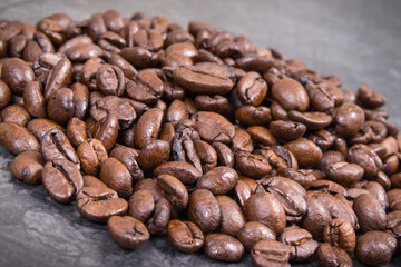 Heap of roasted fragrant coffee grains. Structure concrete