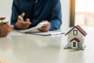 Fototapeta premium Real estate agents hold homes offered to clients after signing contracts. Real estate ideas, moving house, or renting out real estate in the office.