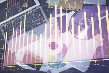 Financial market graph and top view computer on the desktop background. Double exposure. Investment concept.