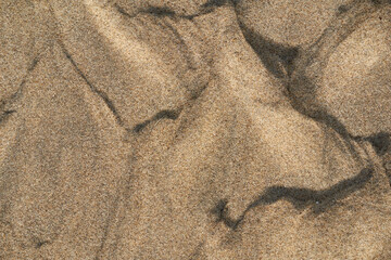 Fototapeta na wymiar Sand on the beach from above. Hilly shape. Close up pattern and texture ideal as background.