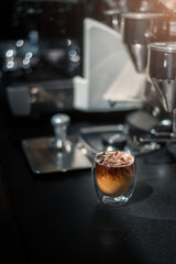 Ice coffee on a black table with cream being poured into it showing the texture and refreshing look of the drink