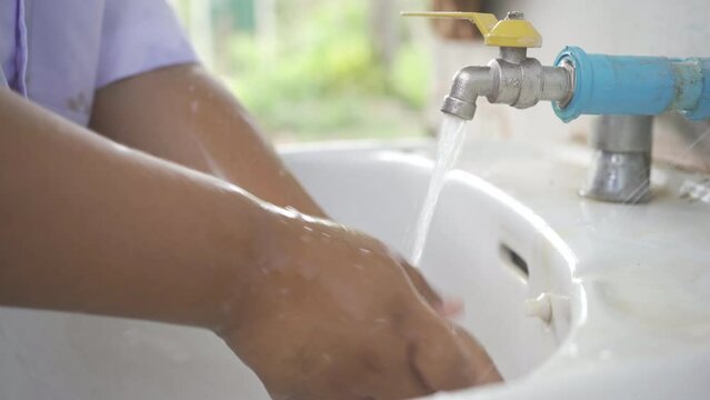 oy washing his hands to clean, prevent germs from entering the body, 4K resolution.