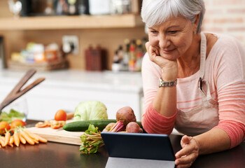 I love these cooking channels. Shot of a woman resting her chin on her hands as she watches a...